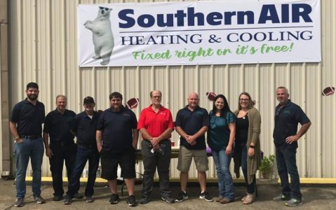 Southern Air Heating & Cooling team members standing in front of company building with branded sign in Port Allen, Louisiana.