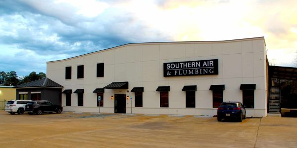 Southern Air & Plumbing commercial building with cream-colored facade, black awnings, and red doors in Louisiana.